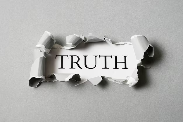 Word ‘TRUTH’ revealed through torn white paper on a gray background, symbolizing honesty, transparency, and uncovering facts
